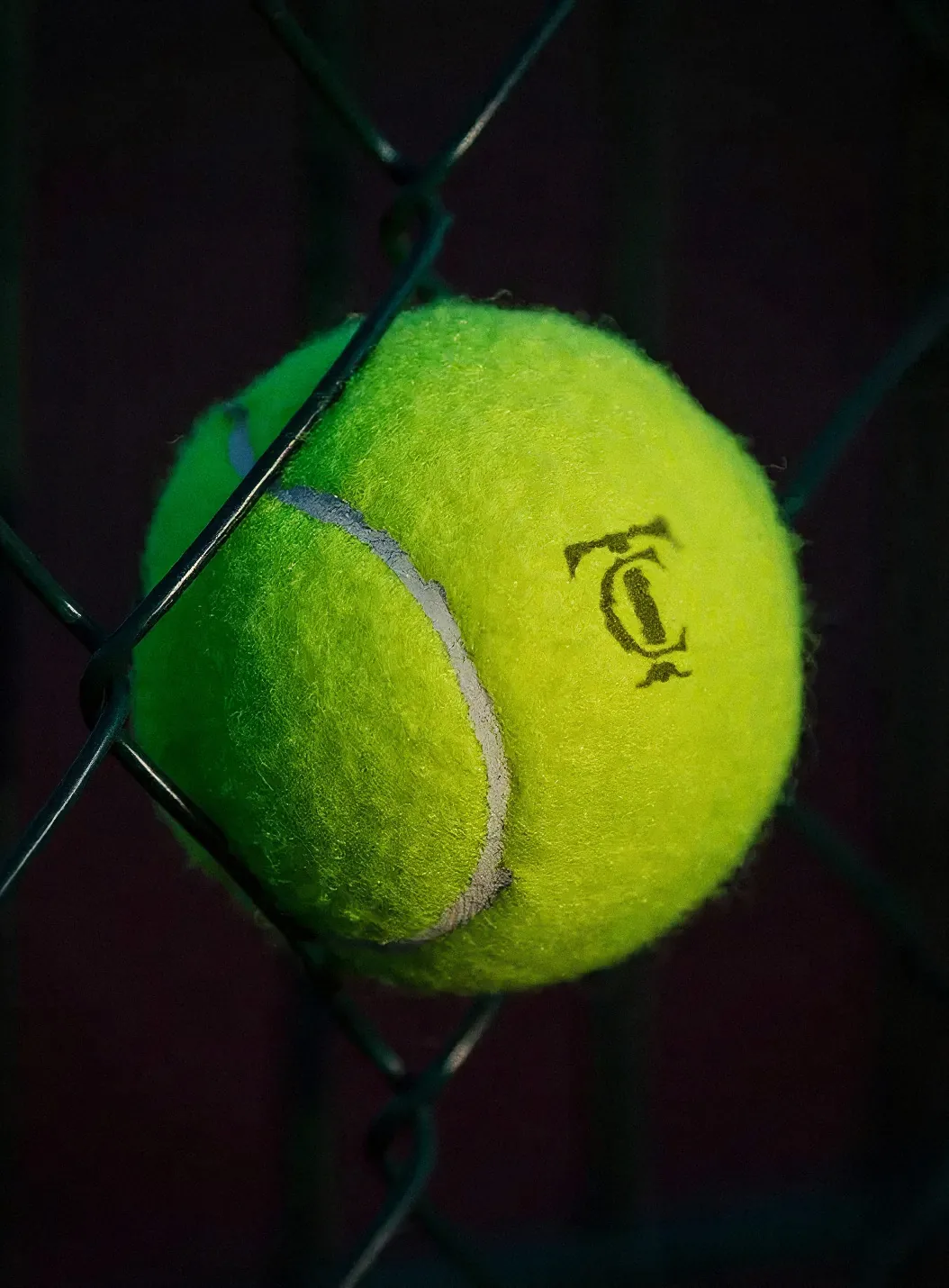 Monograma de CT Tennis Academy impreso sobre una pelota de tenis